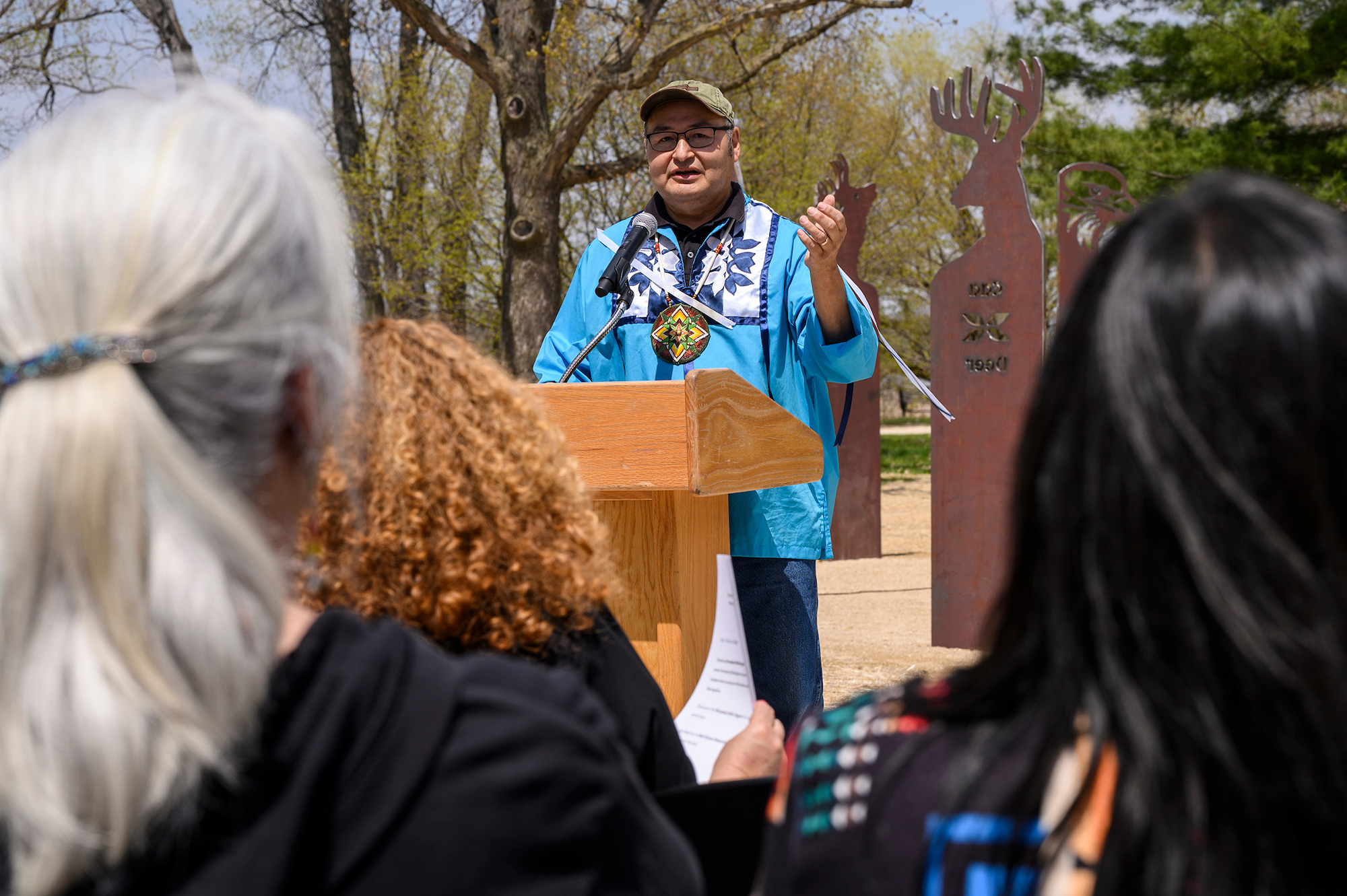 A person standing at a podium speaking to a group of people.